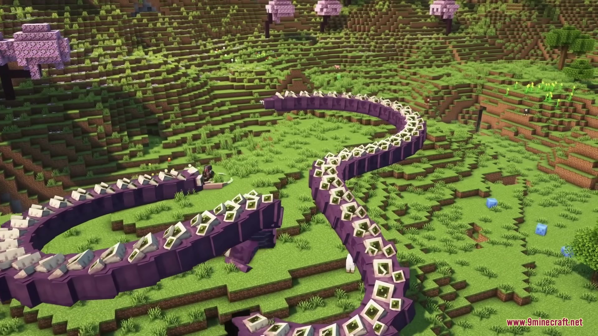 A giant purple segmented worm boss slithers through a grassy Minecraft landscape