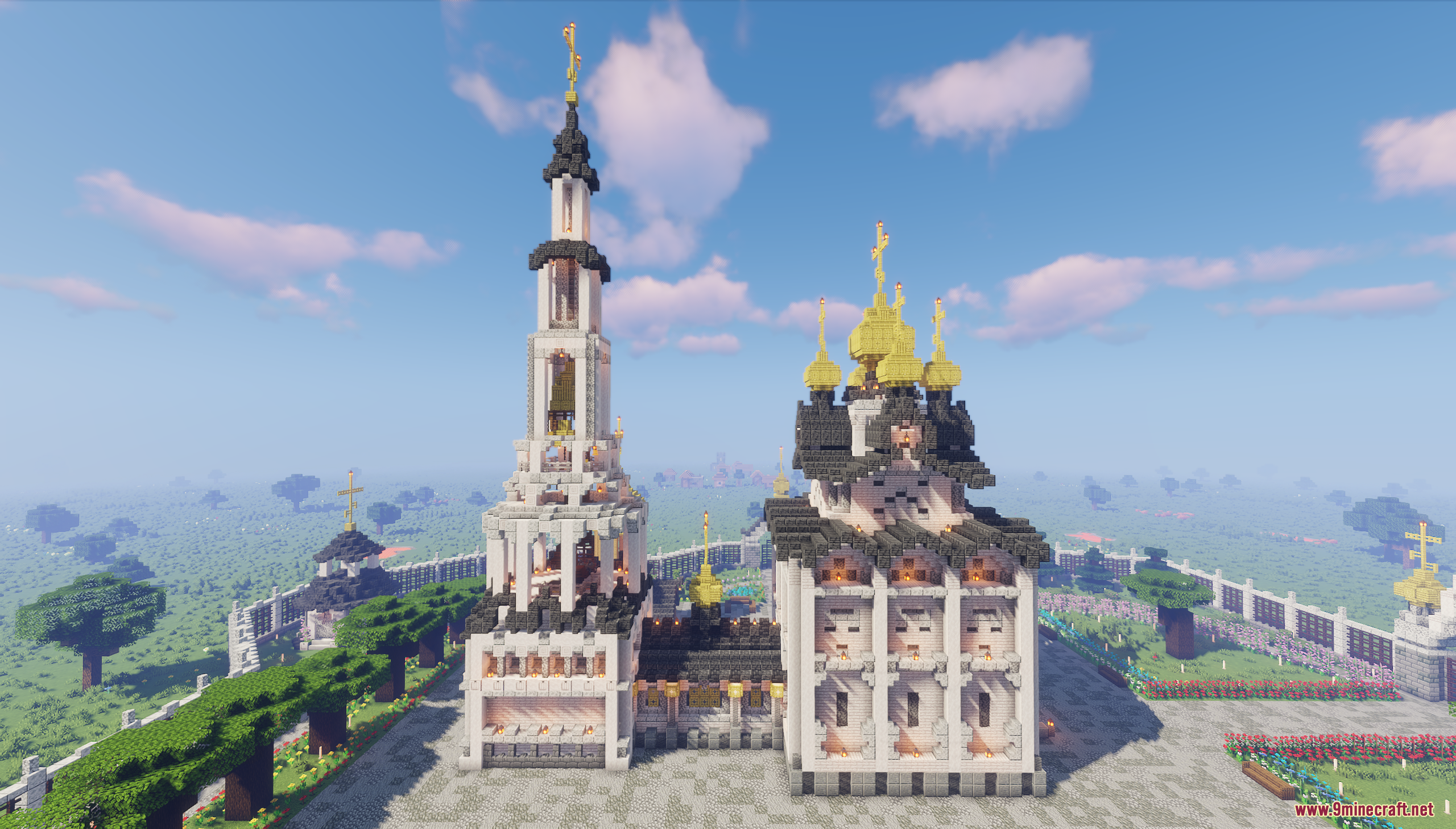 A tall white bell tower standing next to a golden domed church