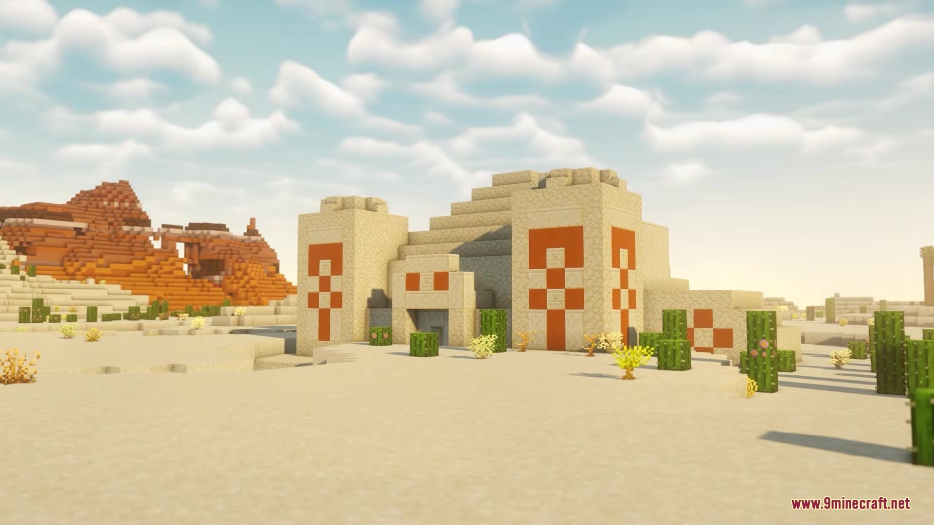 A sandstone desert temple with orange patterns standing near red rock mountains