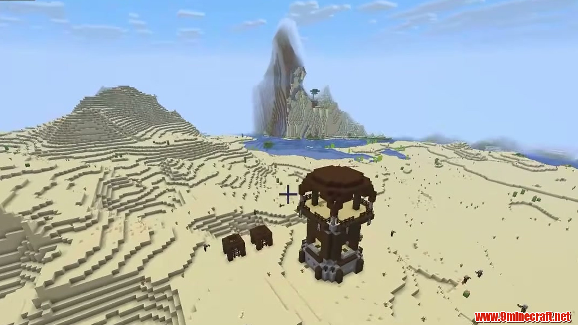 Desert outpost beneath dramatic mountain terrain