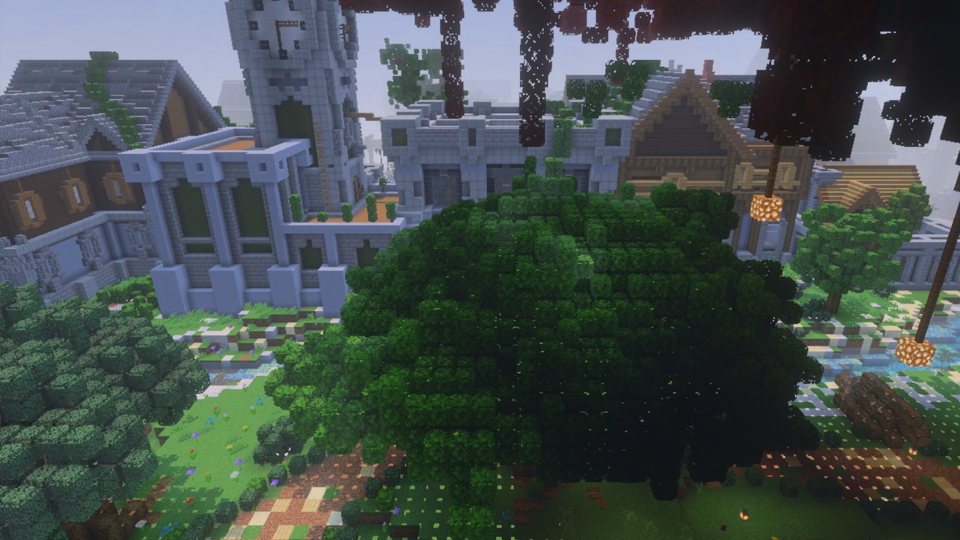 Bushy leaves on a large green tree near a stone clock tower