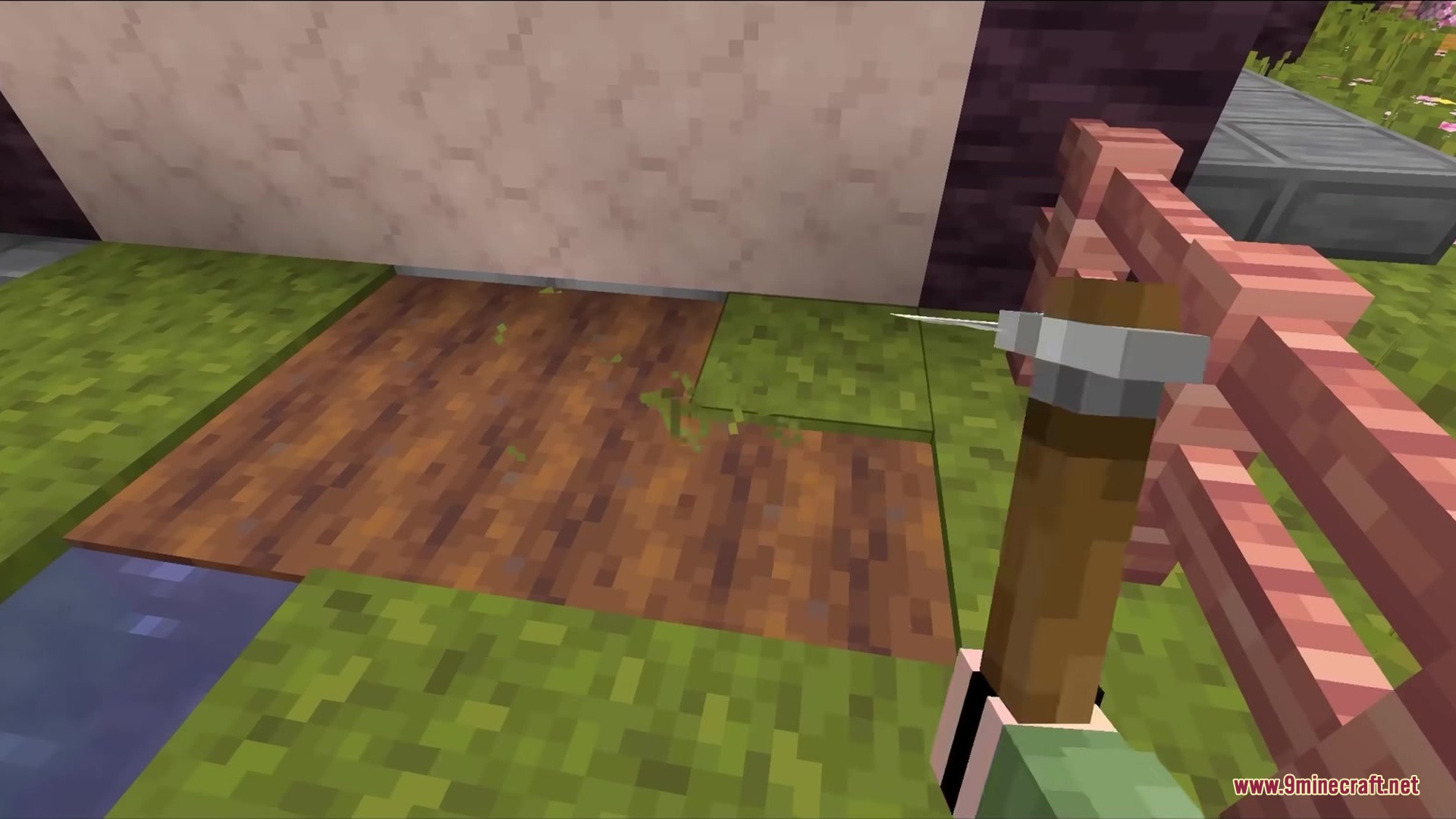 A player holding a 3D stone hoe over a patch of tilled farmland