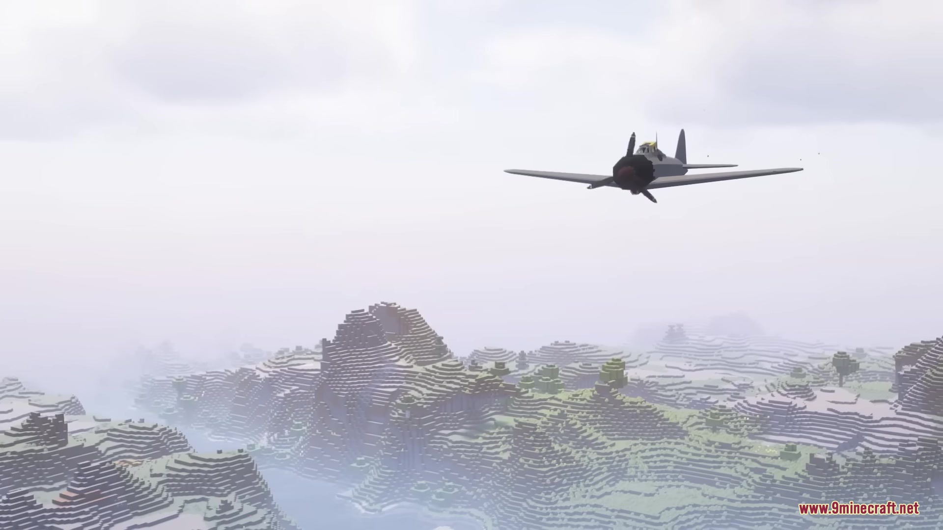 Warfare Wings Mod Screenshot 9 A WWII fighter plane flies over a foggy Minecraft mountain range