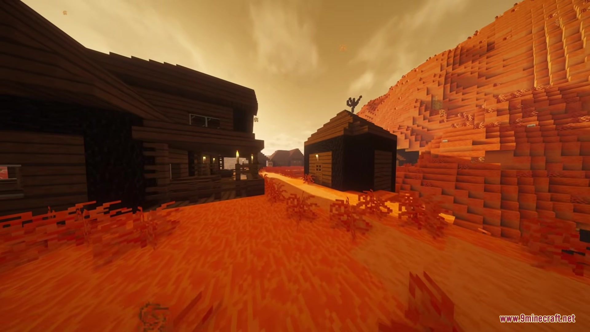 Wushima Mod Screenshot 3 Wooden buildings stand on orange sand under a hazy sky in Minecraft