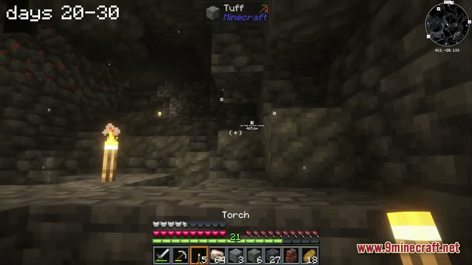 A Cozy Mizuno World Modpack Screenshot 4 A player explores a dark underground cave filled with tuff and deepslate blocks using torches