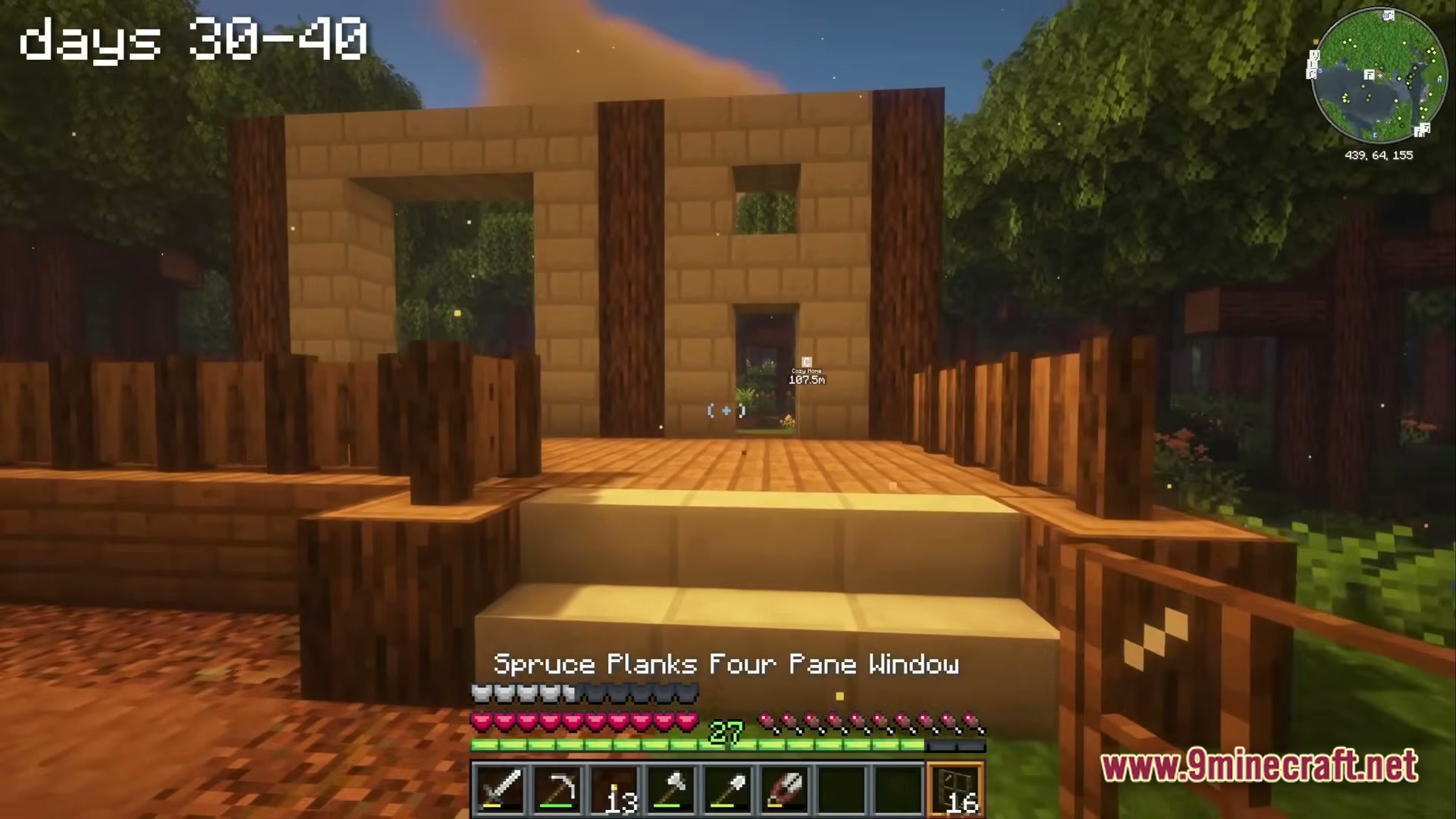 A Cozy Mizuno World Modpack Screenshot 6 A wooden and stone brick structure under construction in a forest biome during sunset