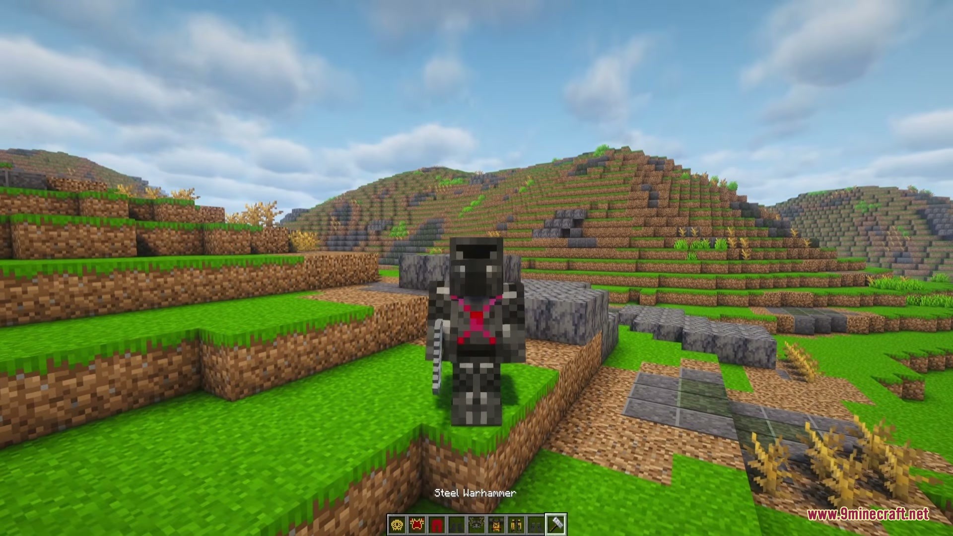 A Game of Blocks Mod Screenshot 1 Minecraft character wearing faction armor and holding a steel warhammer in the hills