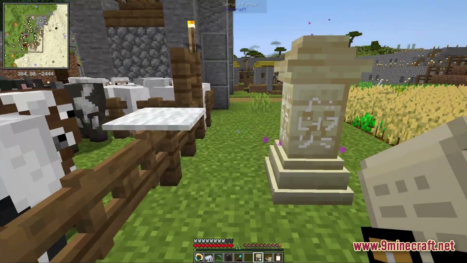 Ancient Kingdoms 3 Modpack Screenshot 1 A Waystone stands near a livestock pen and wheat farm within a fortified village settlement