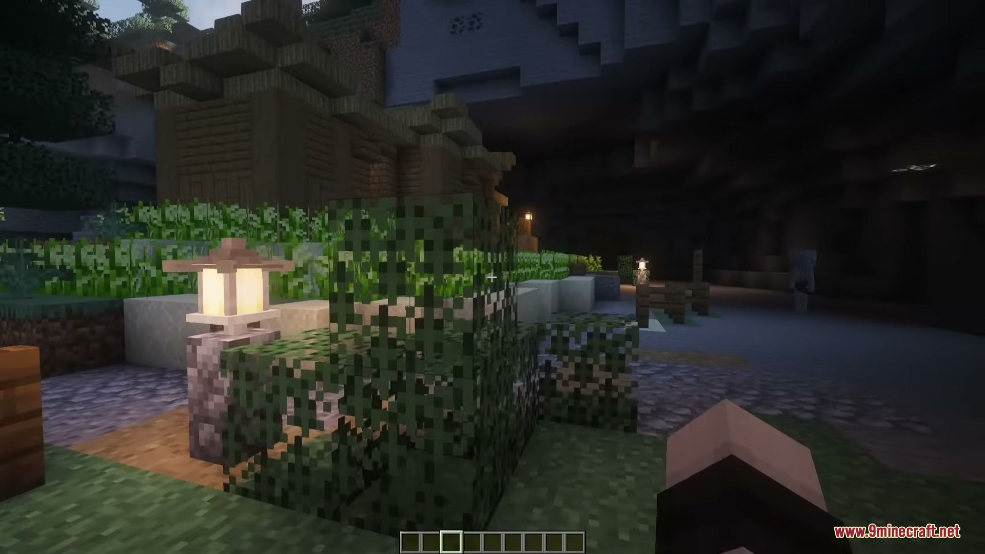 Stone lanterns and leaf blocks decorating a Japanese settlement under a cliff