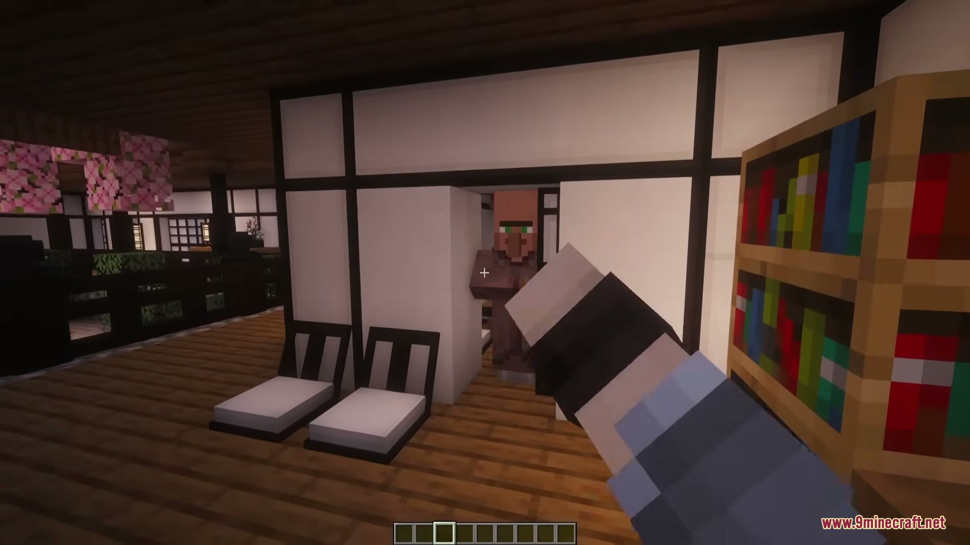A villager stands in the doorway of a traditional Japanese style room with furniture
