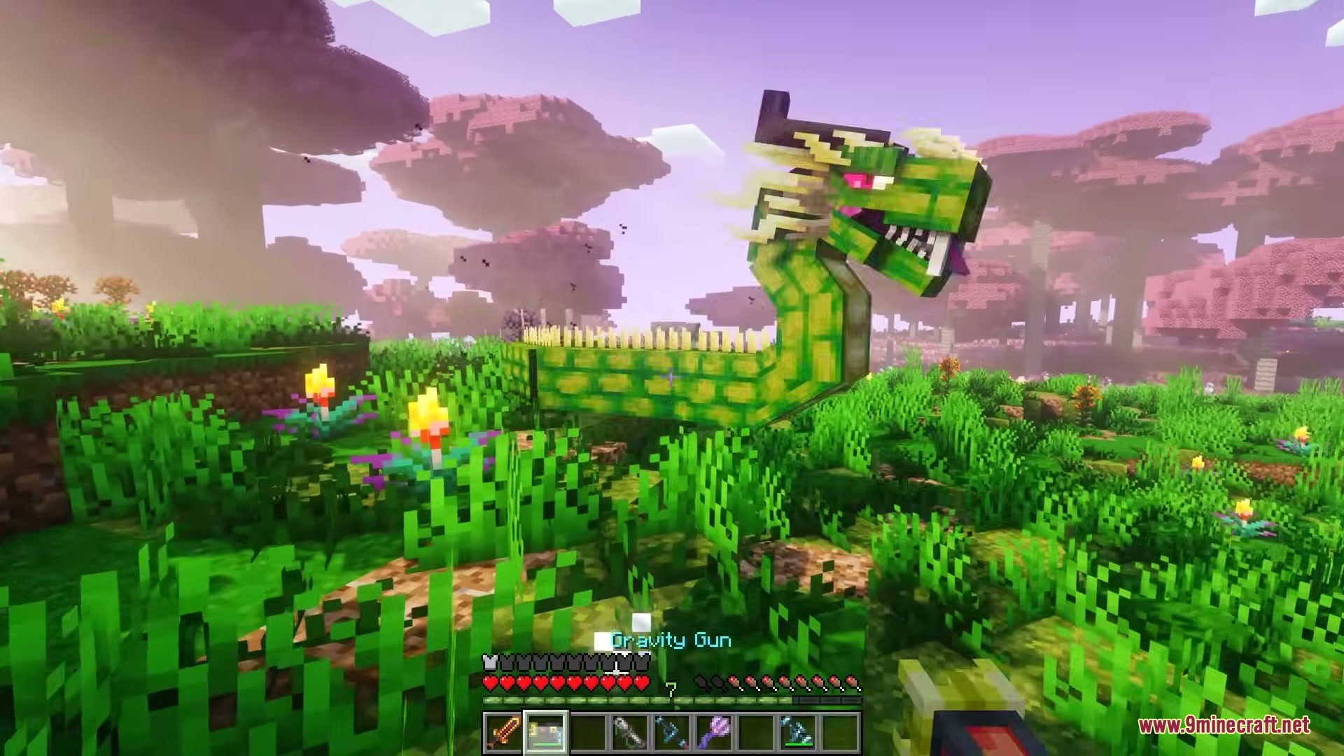 A giant green dragon mob stands in a lush biome with pink trees