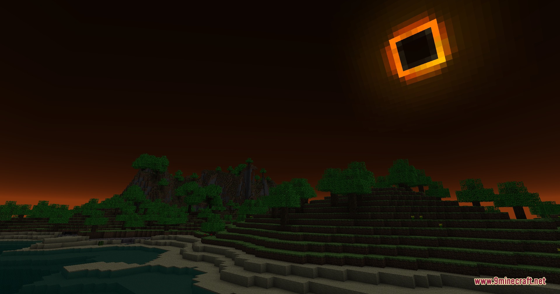 A rare solar eclipse event occurs over a dark forest and hills