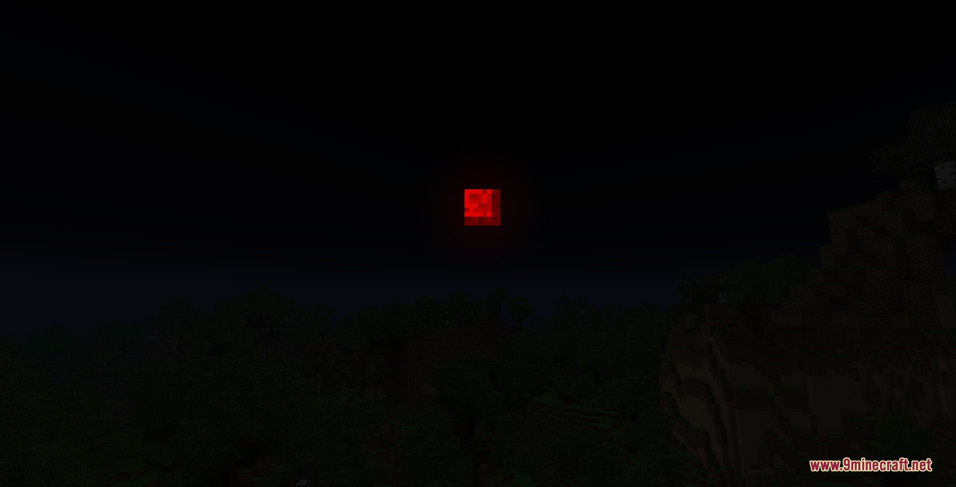 A mysterious red blood moon hangs in the dark night sky above trees