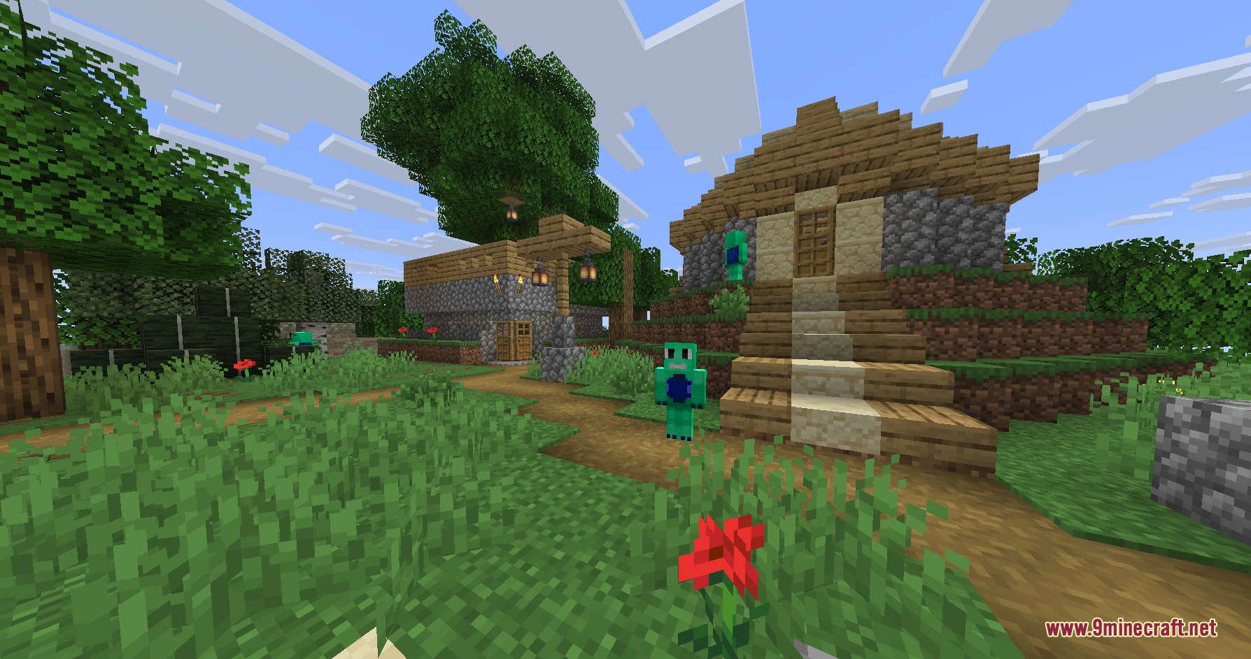 Green creatures stand near small wooden houses in a peaceful village settlement