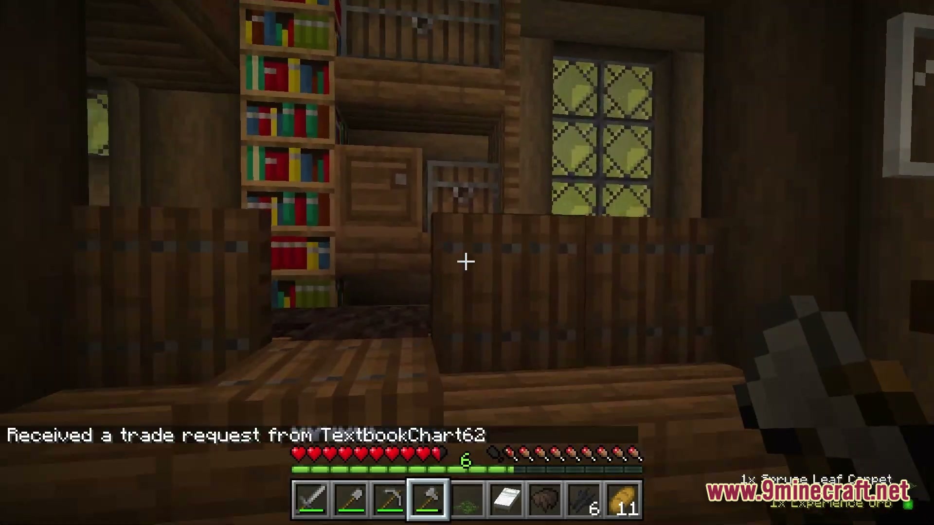 Arcanum Land Modpack Screenshot 5 A player stands inside a wooden building featuring bookshelves, barrels, and a trade request notification