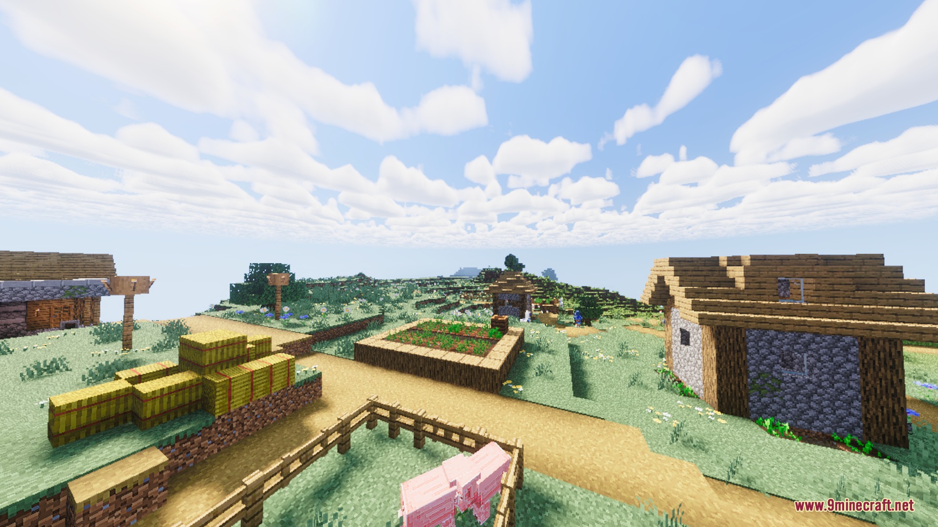 Warm sunlight illuminates a peaceful Minecraft village with hay bales and small houses