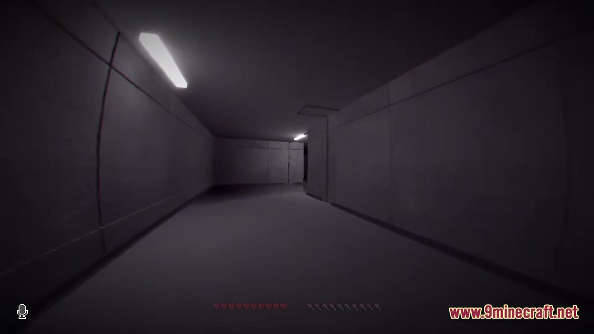 Backrooms Found Footage Modpack Screenshot 4 A first-person perspective of a dimly lit, concrete hallway with fluorescent lights and a VHS-style overlay