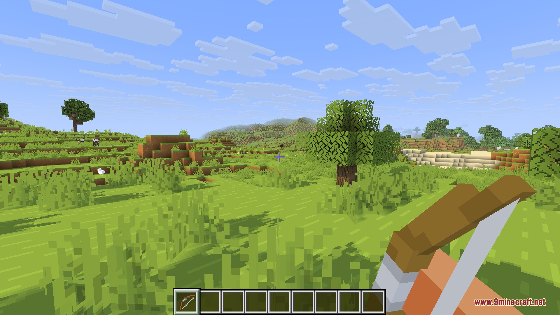 Player holding a three dimensional bow while looking over a simplified grassy landscape