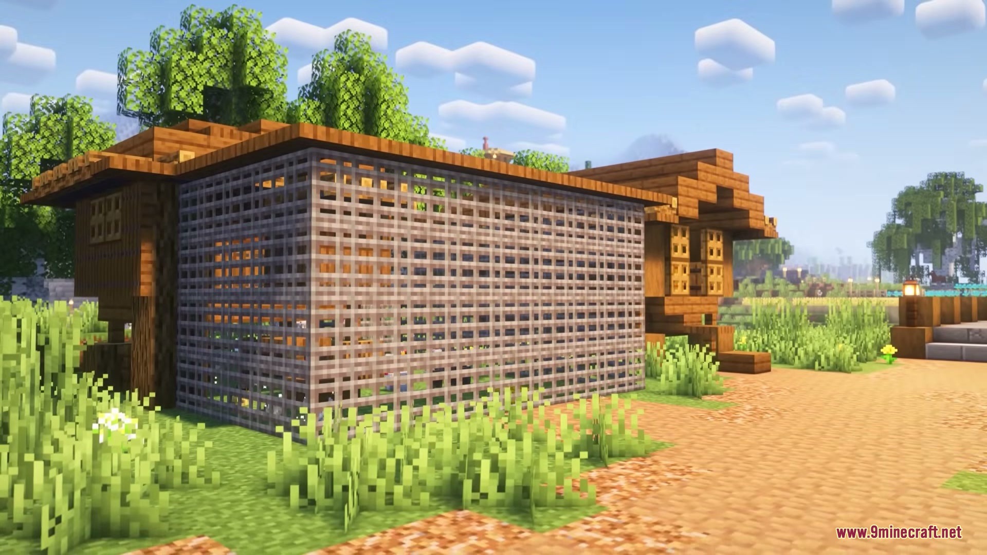 A wooden farmhouse with chainlink mesh walls built for animal pens