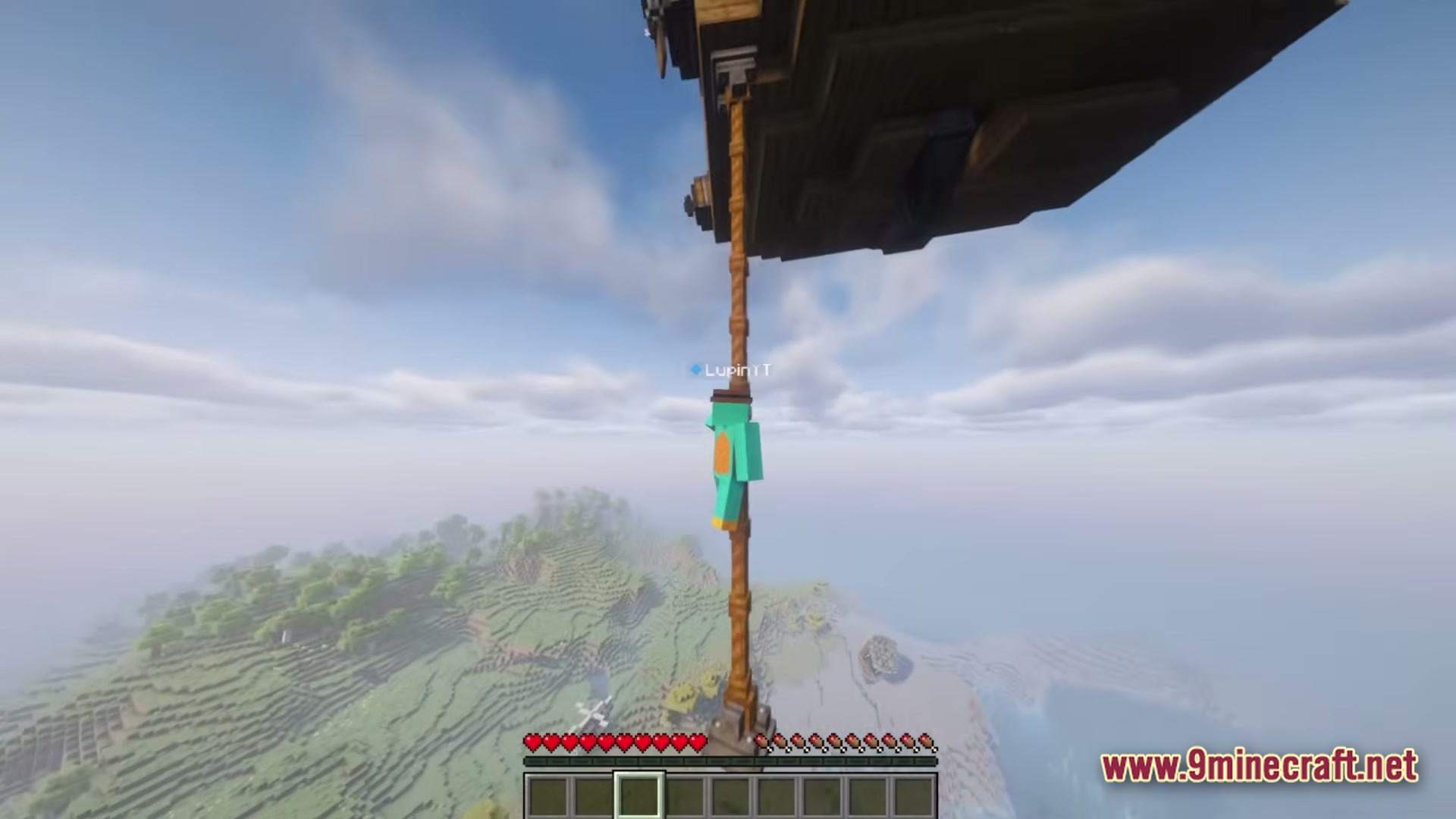 A player character hangs from a rope pulley attached to a flying wooden airship structure