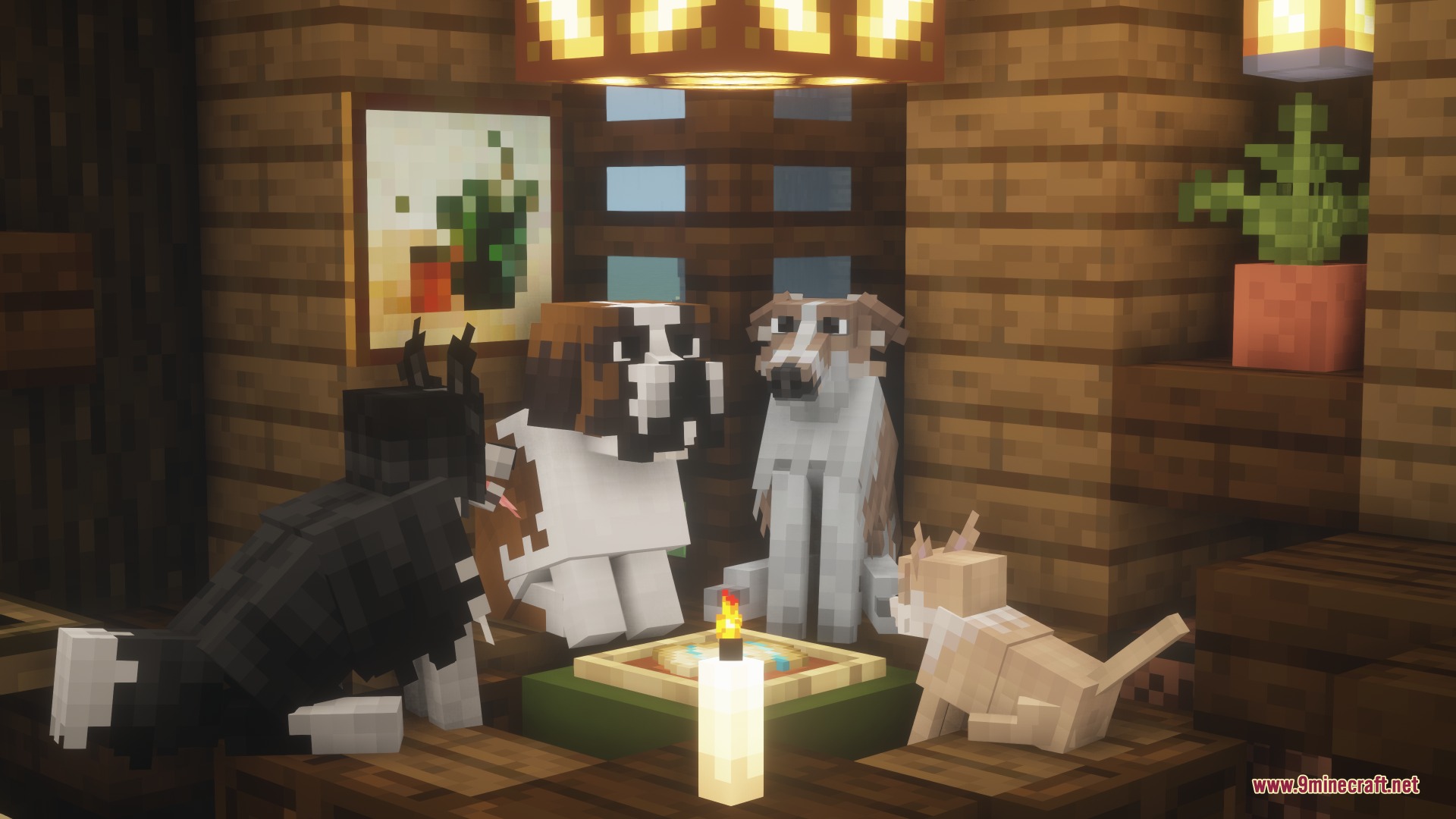 Various dog breeds gathered around a table with a pizza and a candle