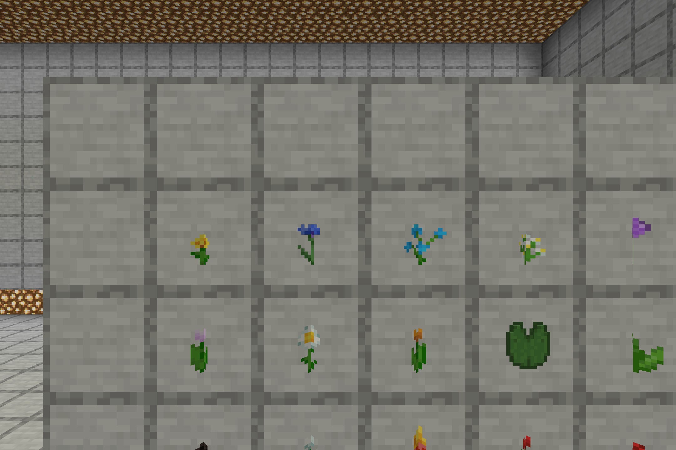 Various Minecraft flowers and a lily pad displayed in item frames on stone