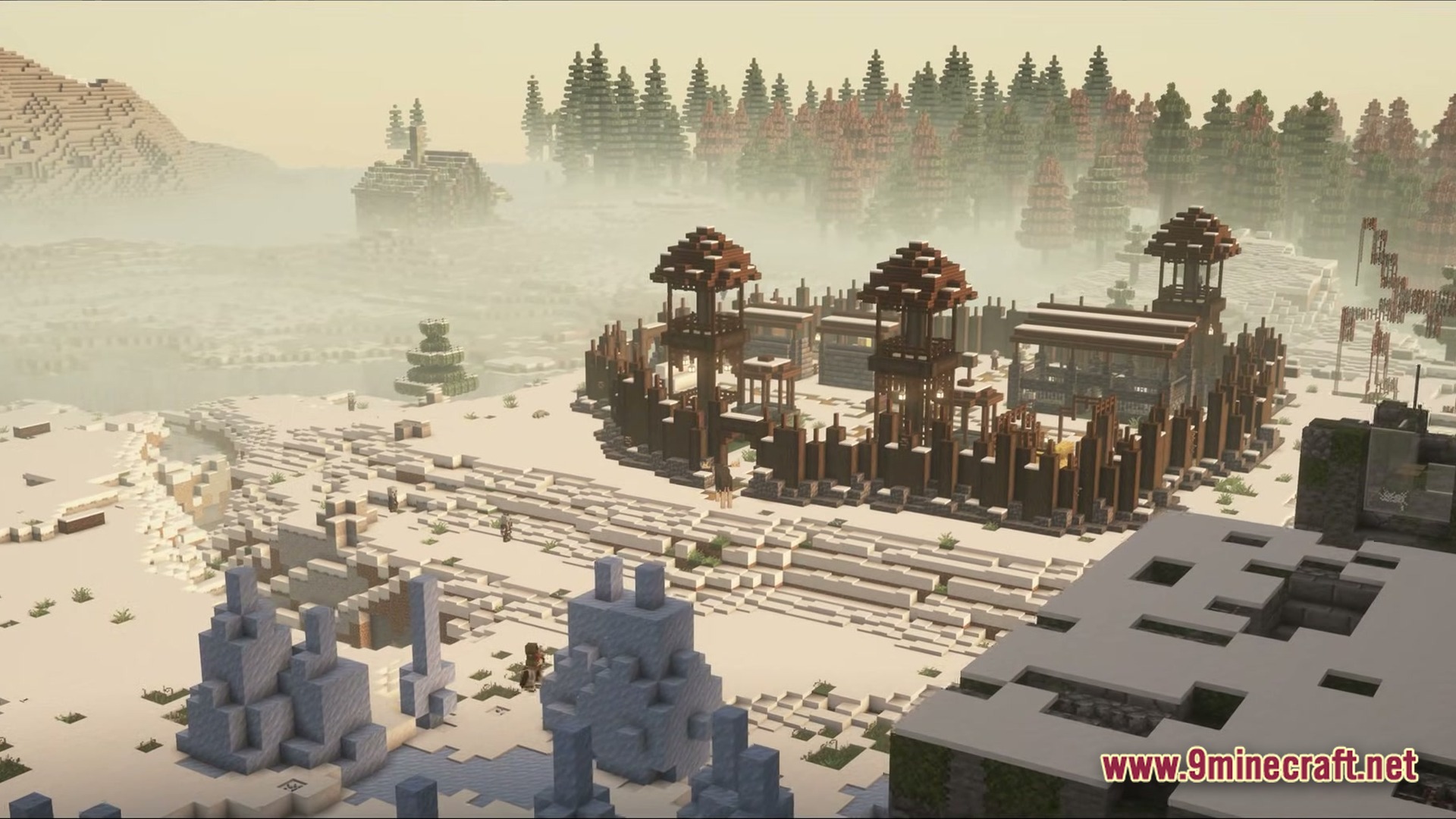 A fortified wooden outpost stands within a snowy, fog-filled landscape near a dense pine forest