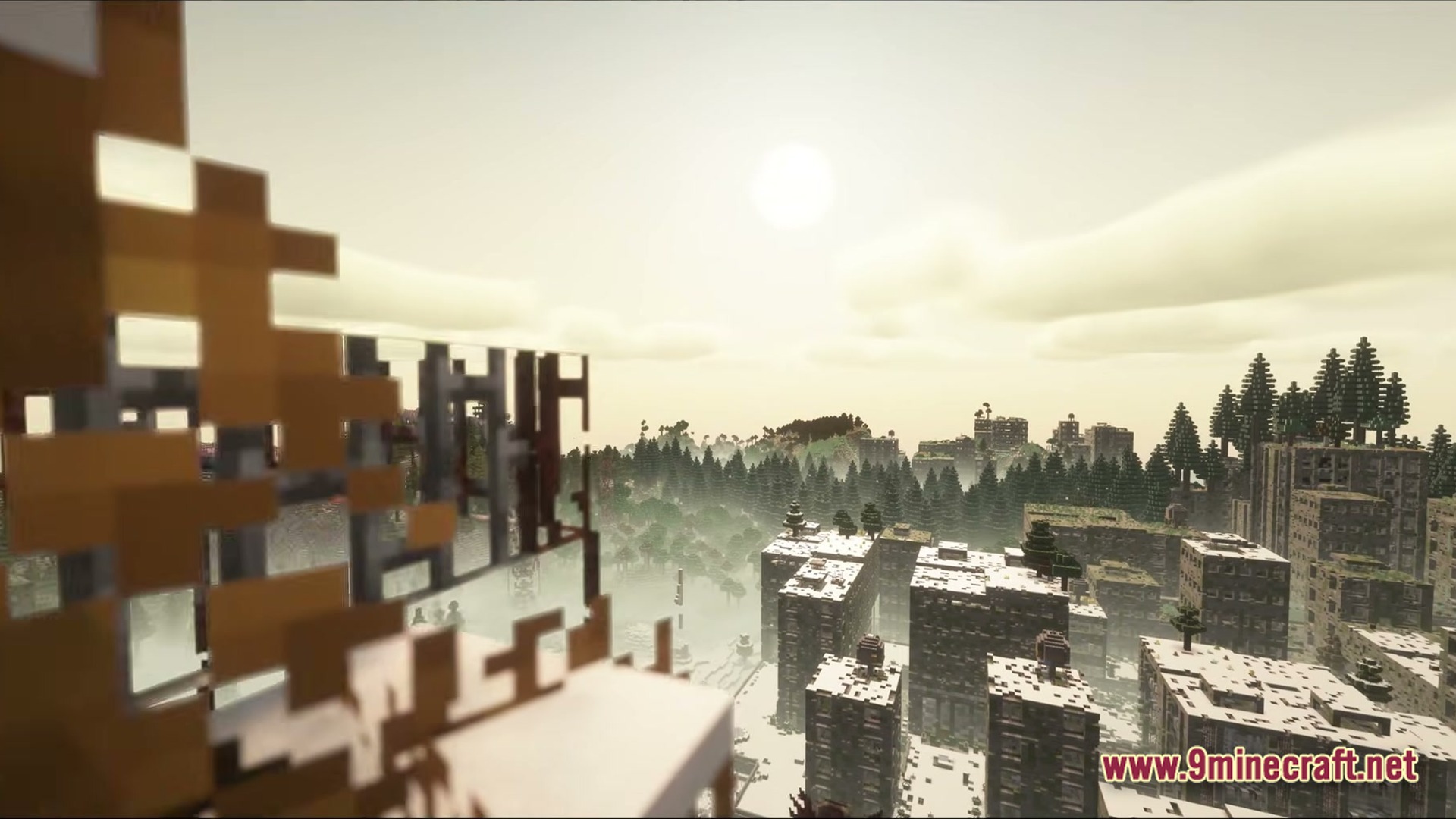An abandoned, snow-covered city landscape surrounded by a dense evergreen forest under a hazy sky