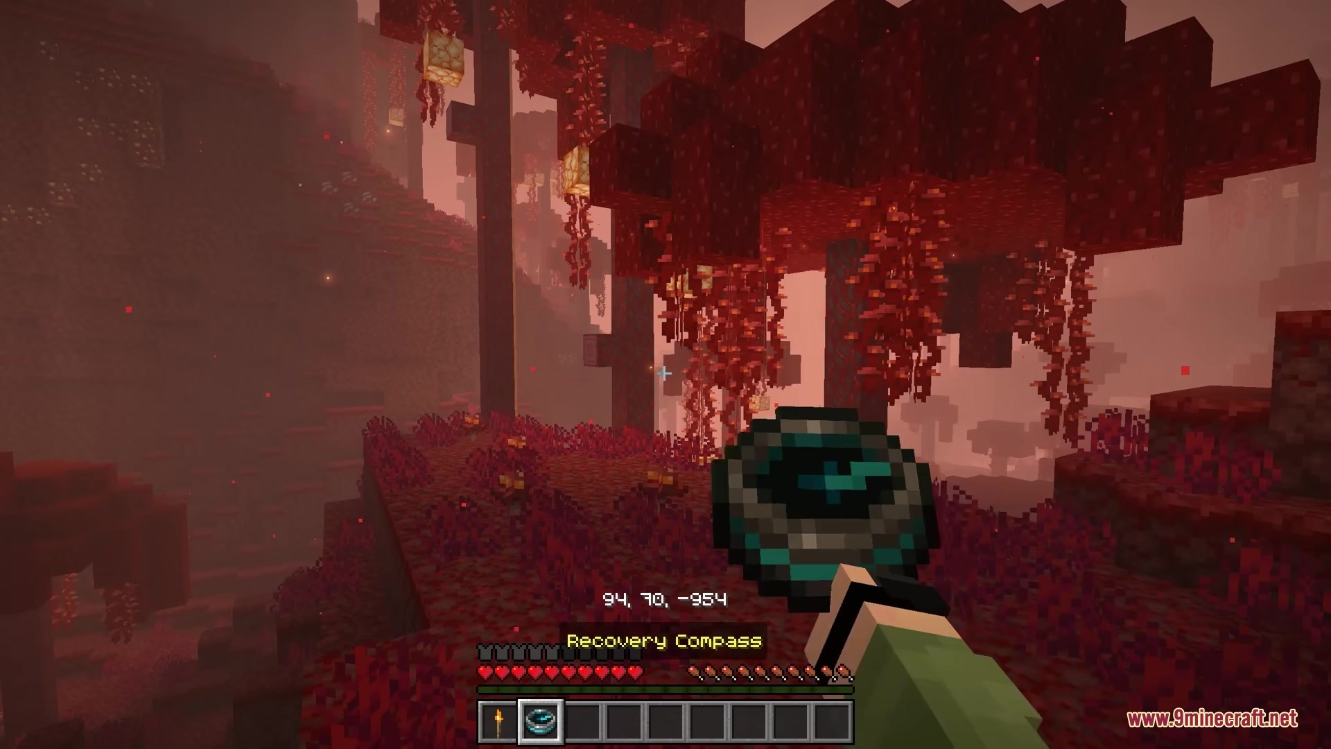 Bits and Balance Mod Screenshot 7 A player holding a Recovery Compass while exploring the Crimson Forest biome
