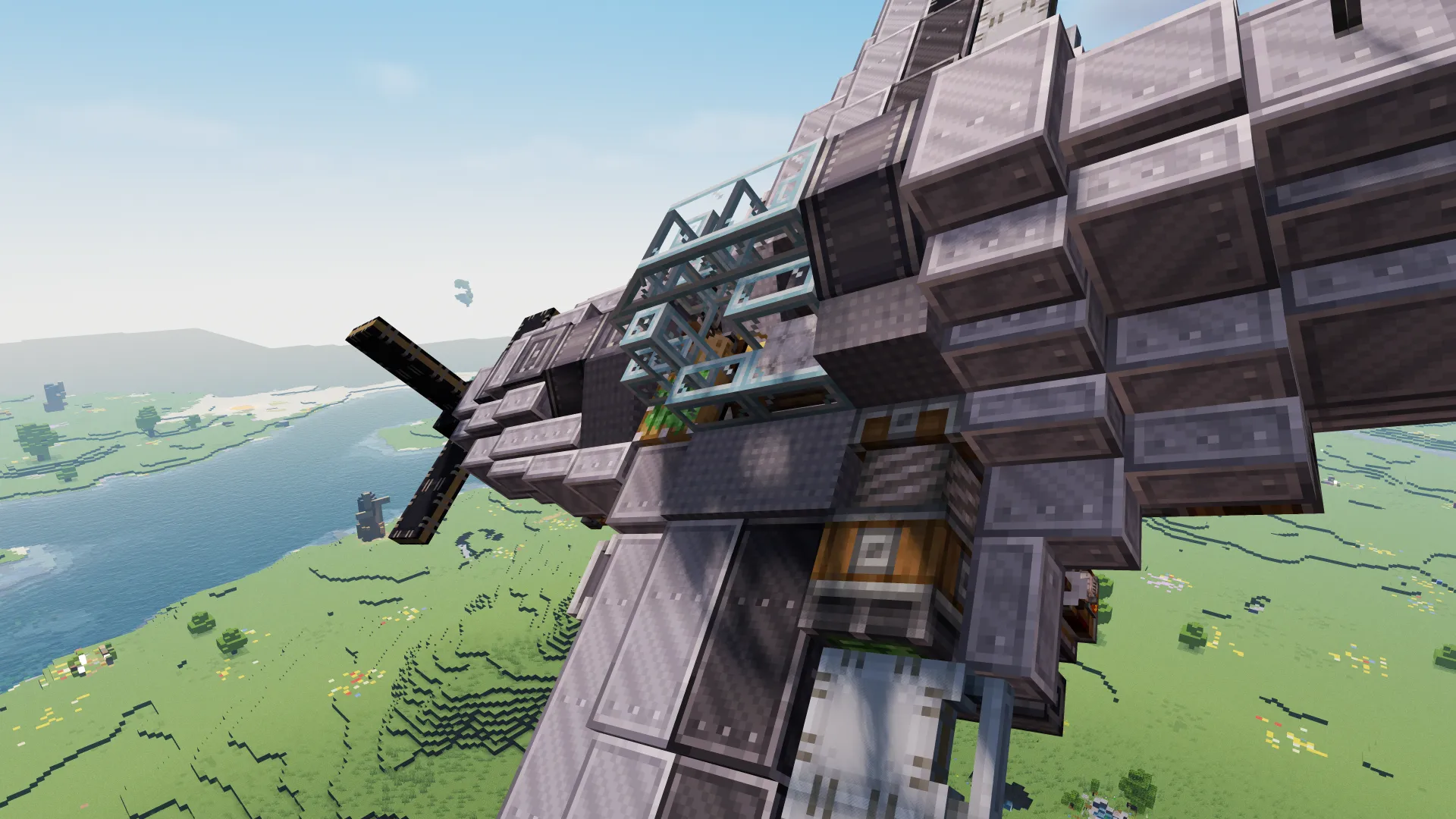 A detailed Minecraft fighter plane flying high above a river and green hills