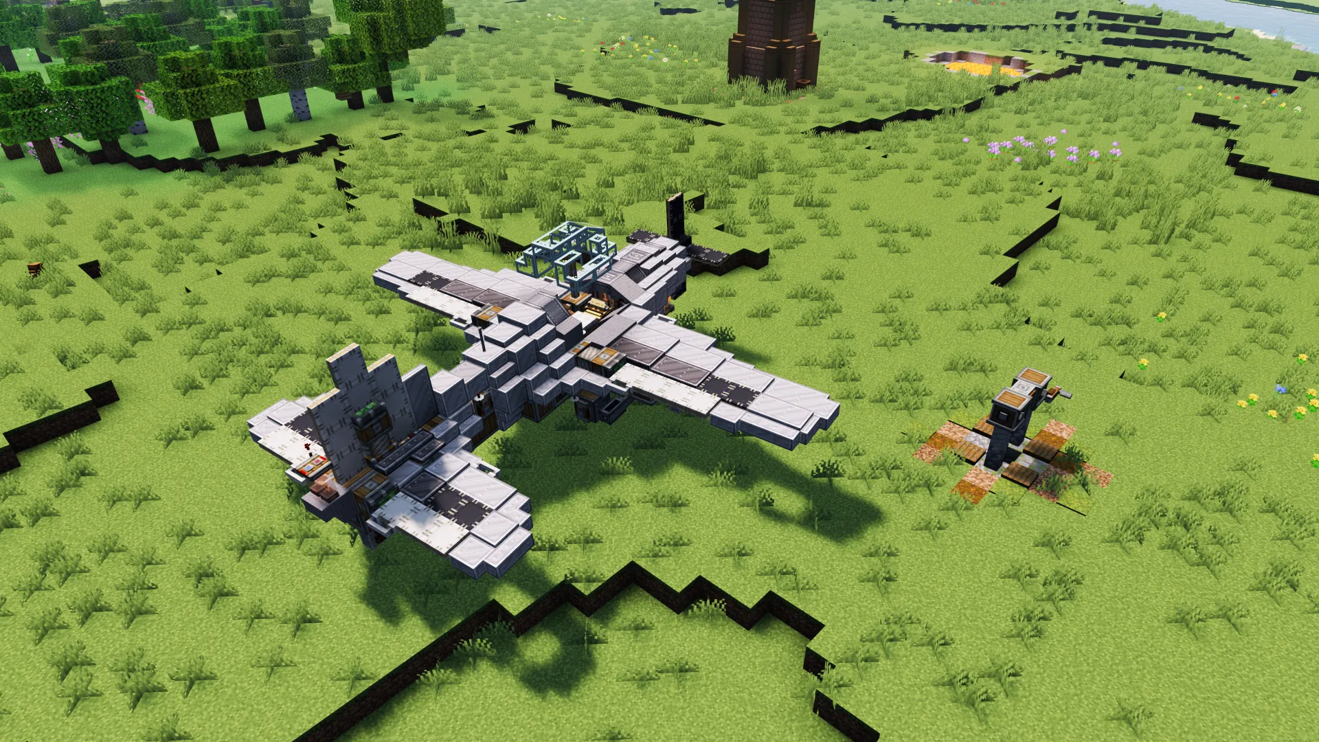 A large grey aircraft parked on a grassy field in a Minecraft world