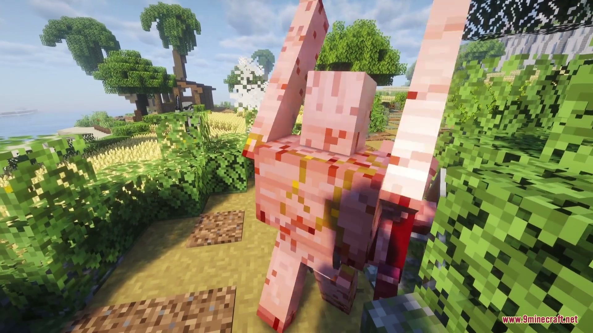 A large pink mutant creature stands amidst green bushes and trees