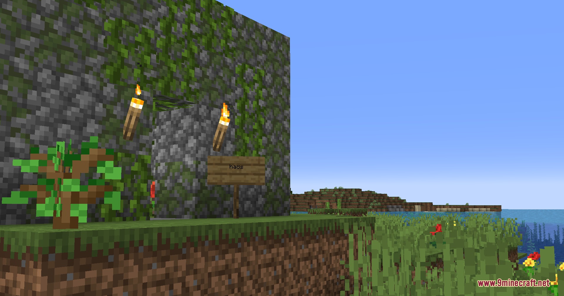 Builds N Barrens Mod Screenshot 2 A small mossy cobblestone house with torches and a sign in the grass