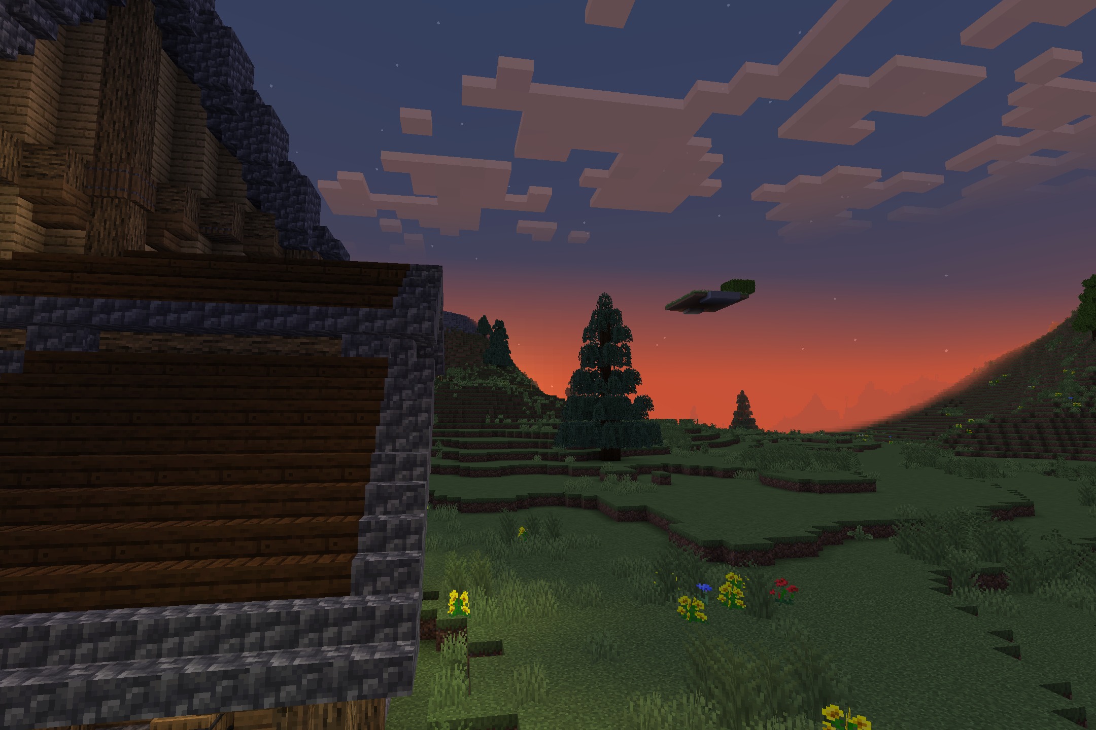 BwW Resource Pack Screenshot 10 Rustic building overlooking a grassy field with pine trees under a colorful sky
