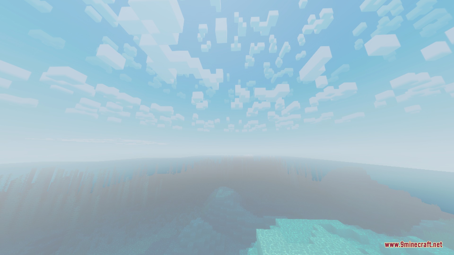 Blocky clouds drift across a bright sky above a misty ocean landscape