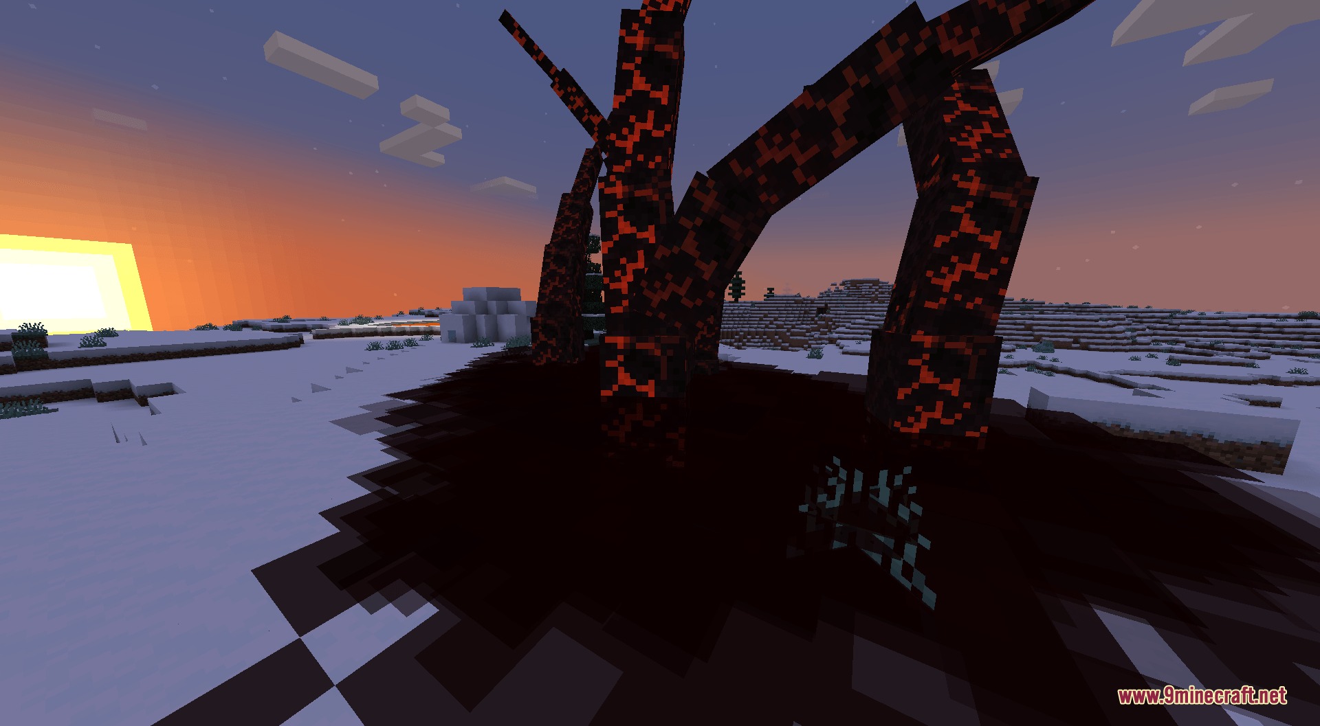Dark corrupted trees standing in a snowy landscape during a sunset