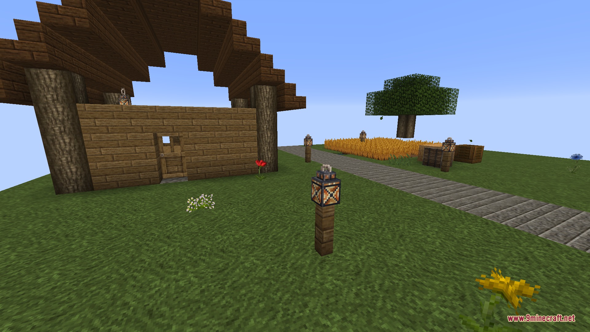 A small wooden house stands near a path leading to a wheat field