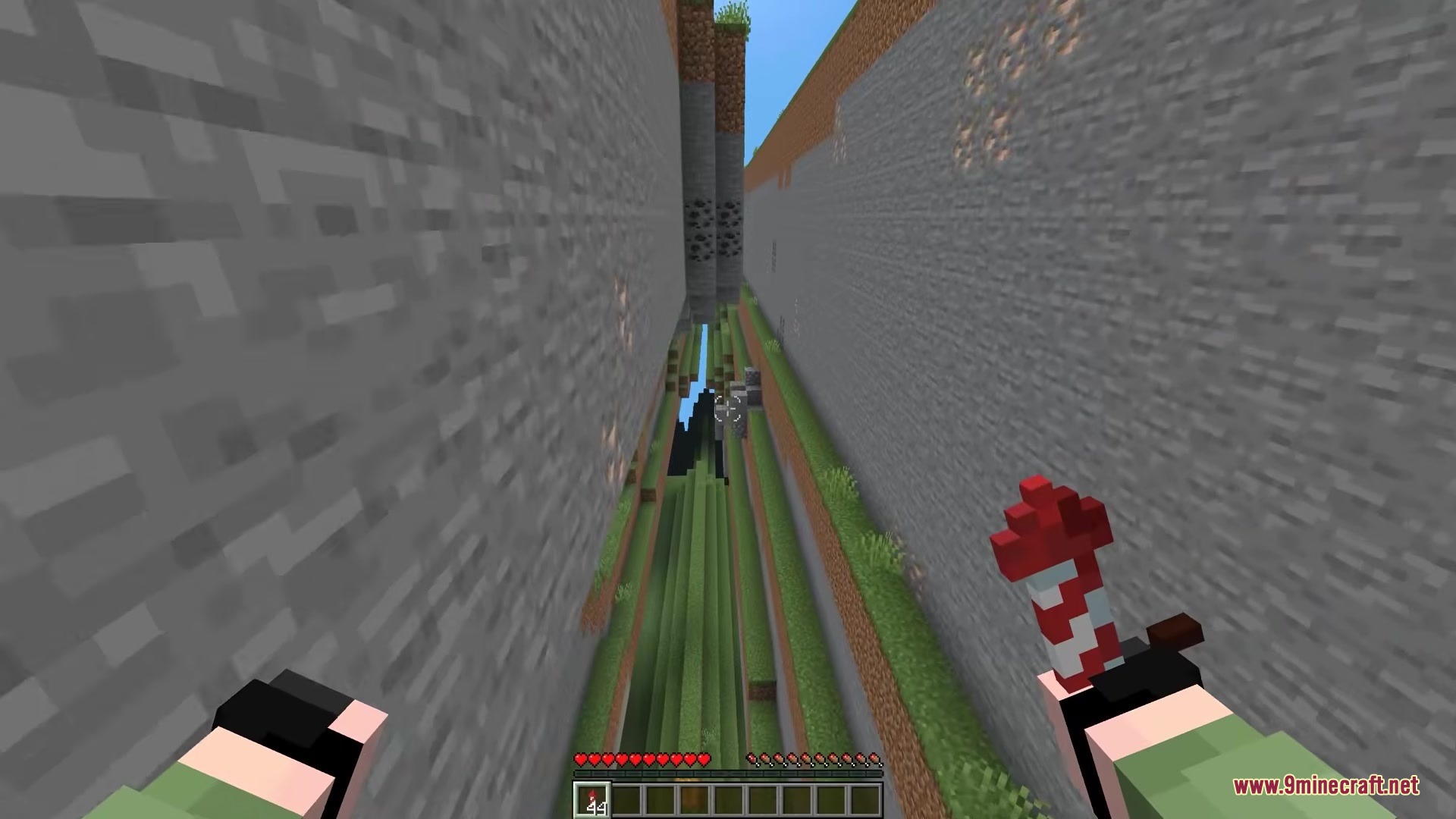Classic Farlands Mod Screenshot 6 Player holding a firework rocket while flying through a deep vertical terrain gap