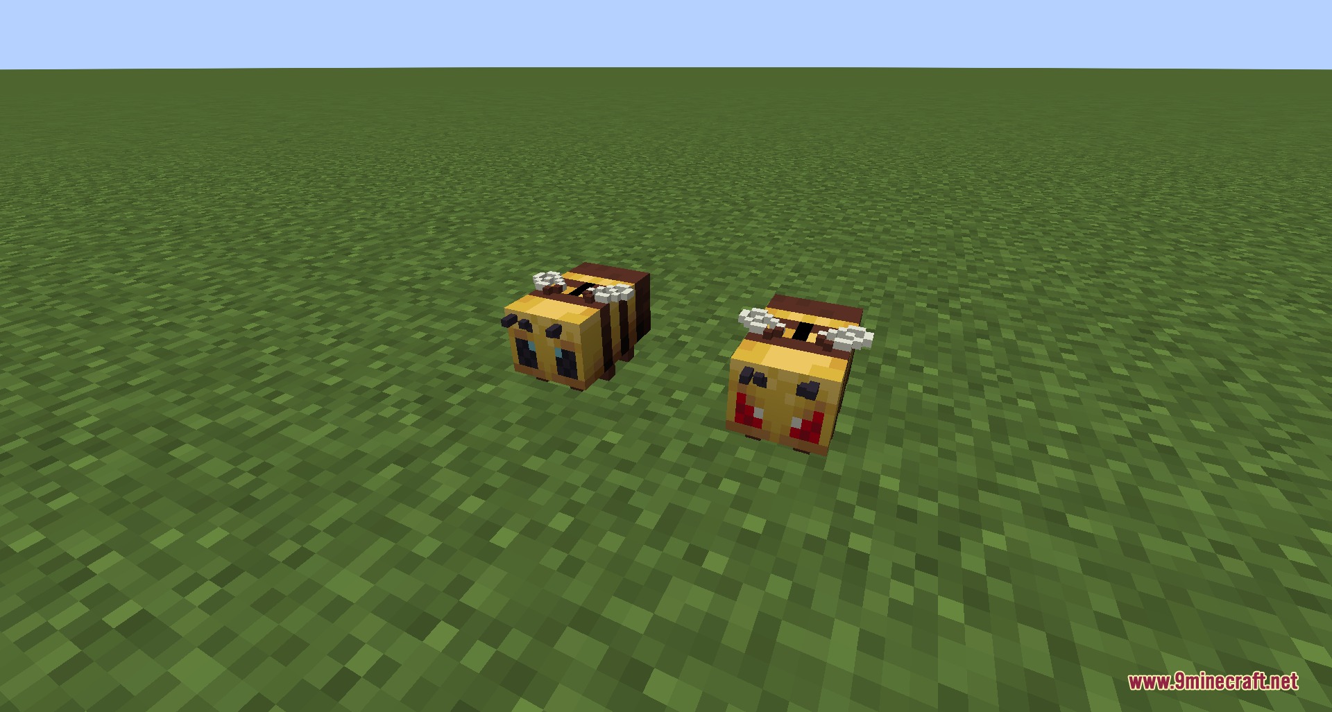 Two bee shaped coin banks sitting on the green grass field