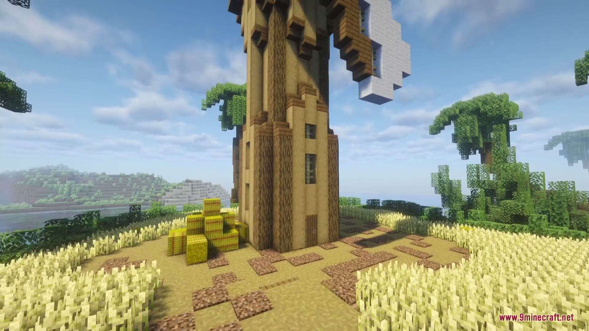 Combustive Ordnance Expansion Mod Screenshot 1 A tall wooden windmill tower standing in a field of golden wheat