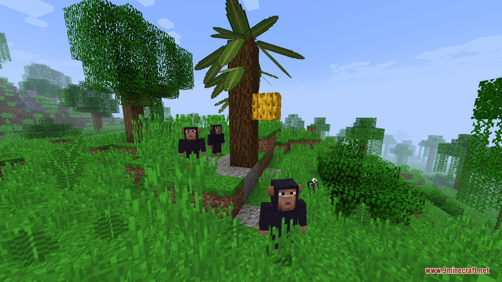 Three monkeys standing in a jungle biome next to a tropical tree