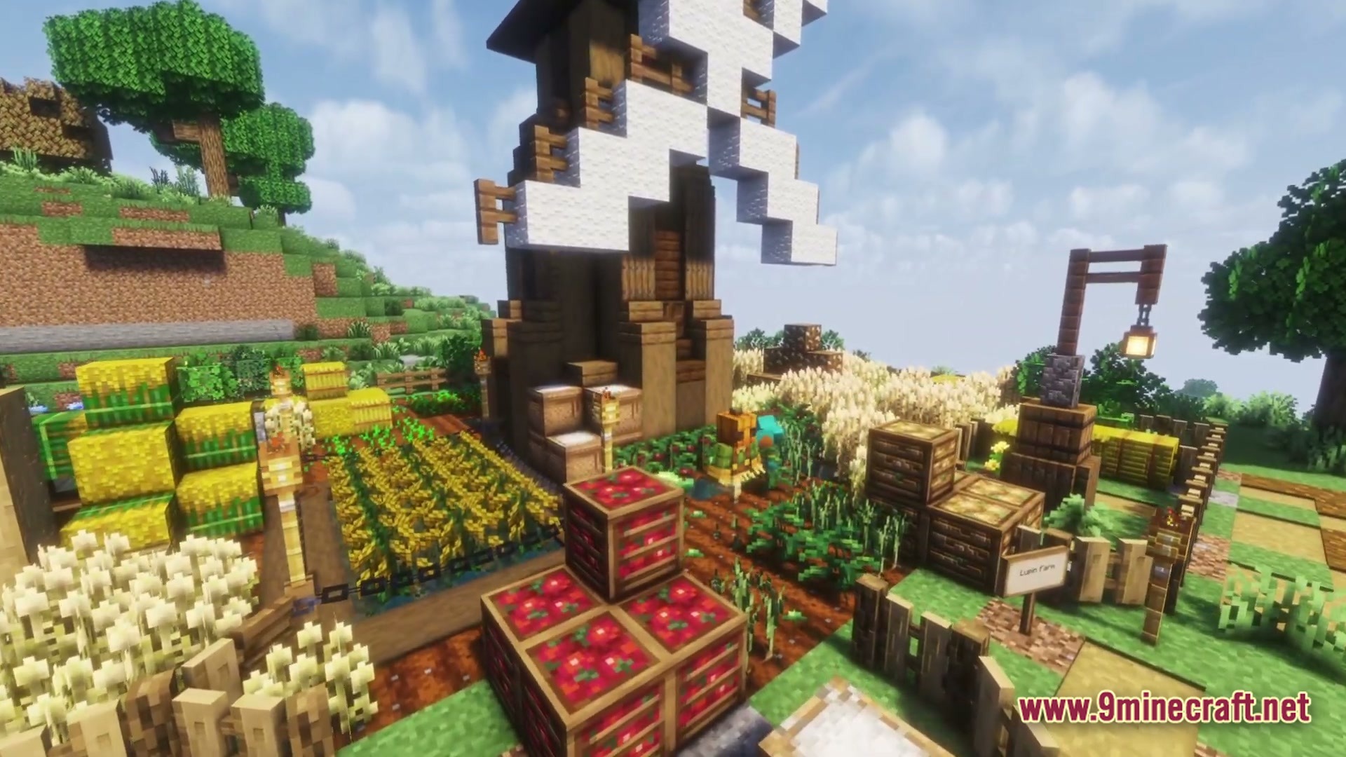 Cozy Zen Modpack Screenshot 4 A large wooden windmill stands over a detailed farm with various crops, crates, and hay bales