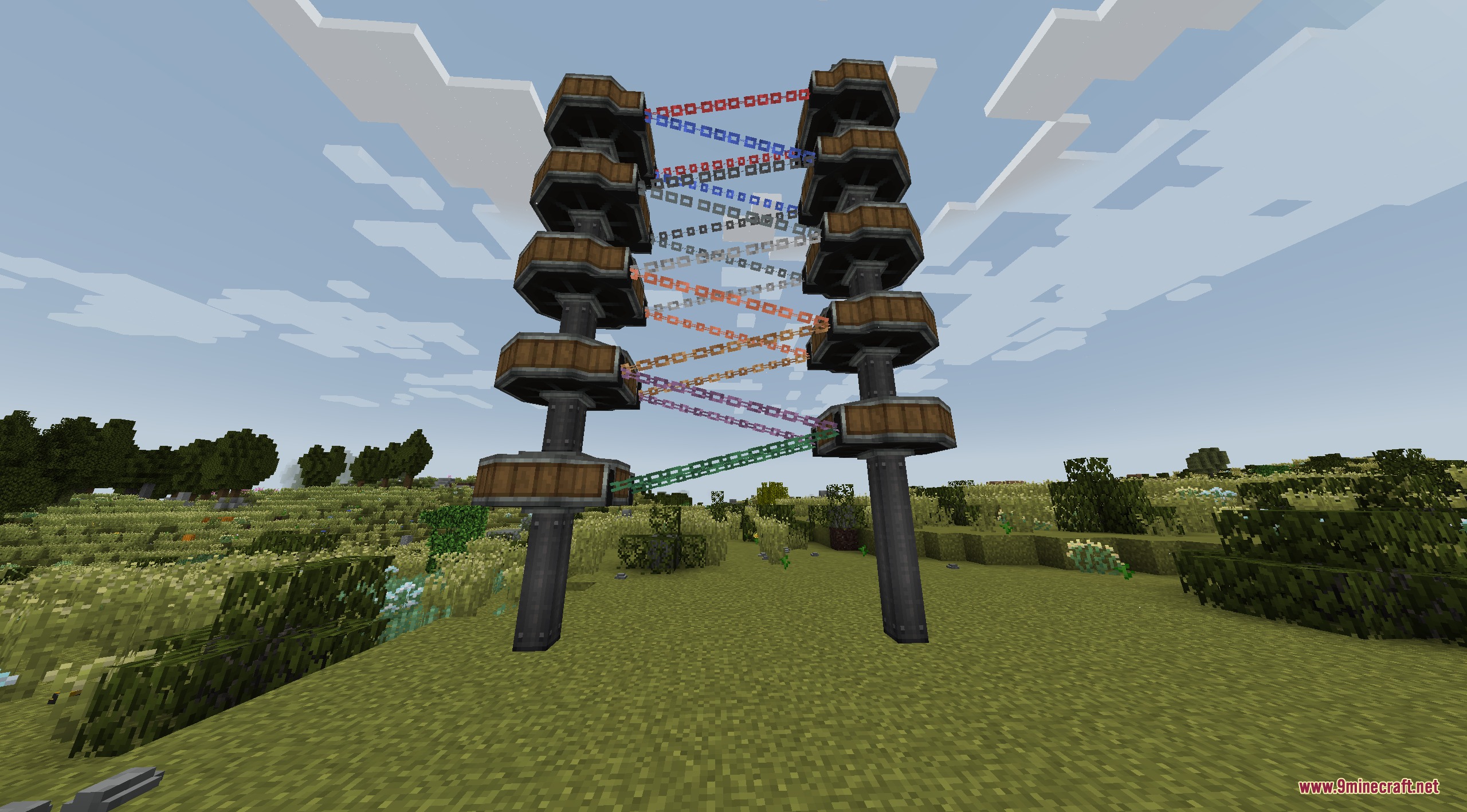 Create Chain Conveyors Compat Mod Screenshot 1 Various colored chains linking two vertical towers to form a conveyor system