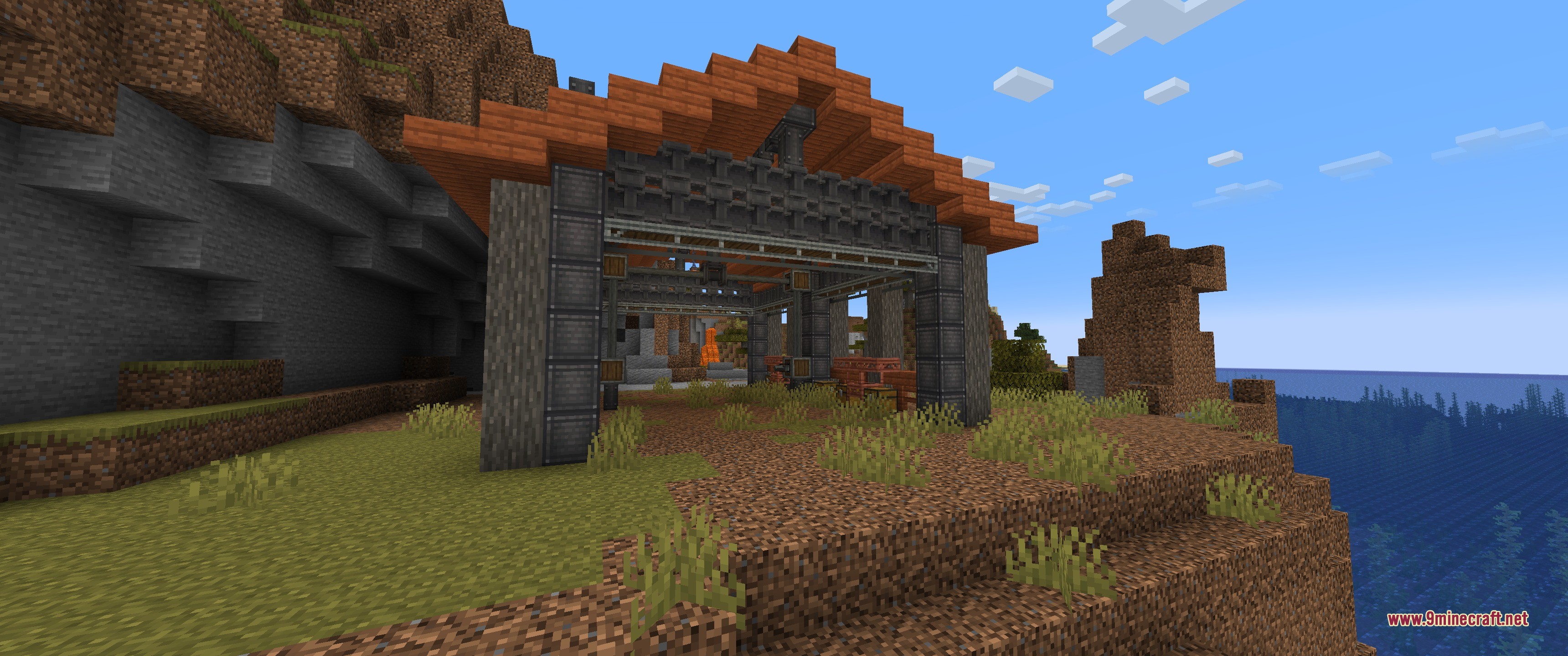 A dark stone hangar with an acacia roof sits near the ocean