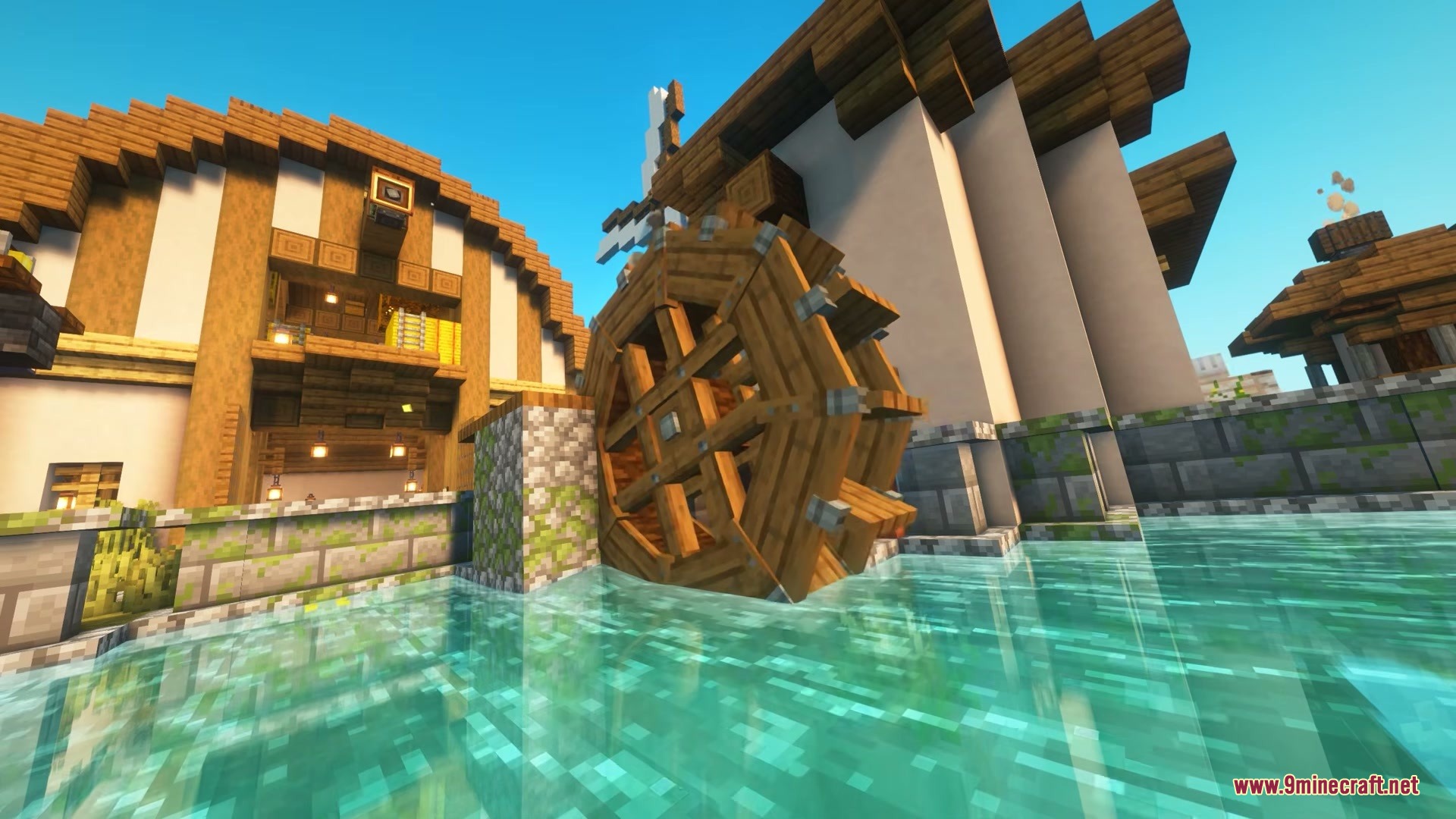 A large wooden water wheel built next to a house in the village