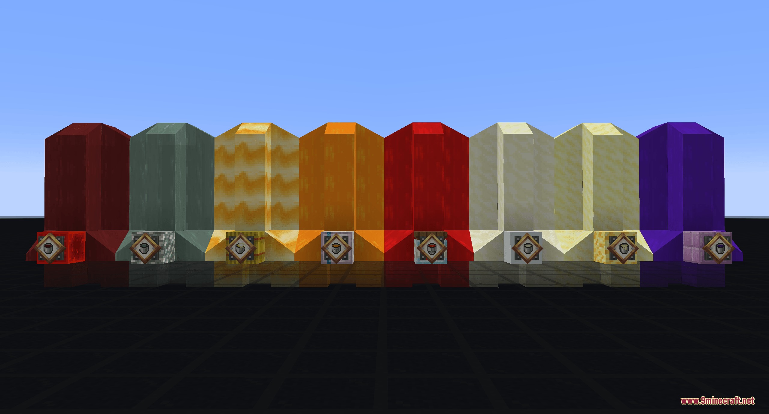 Eight colorful fluid tanks with mechanical bases standing in a row