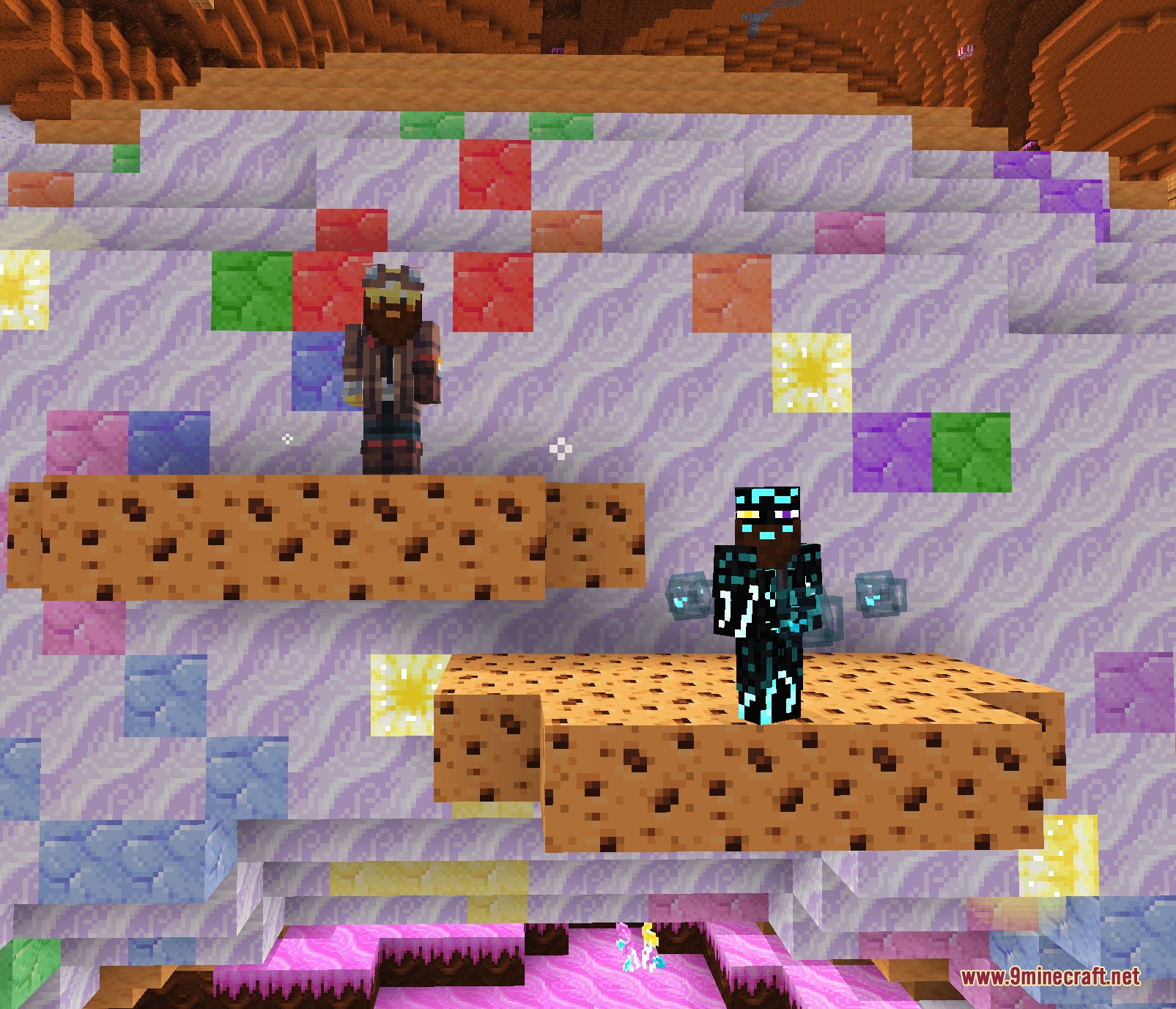 Two players standing on giant cookie platforms in a colorful candy biome