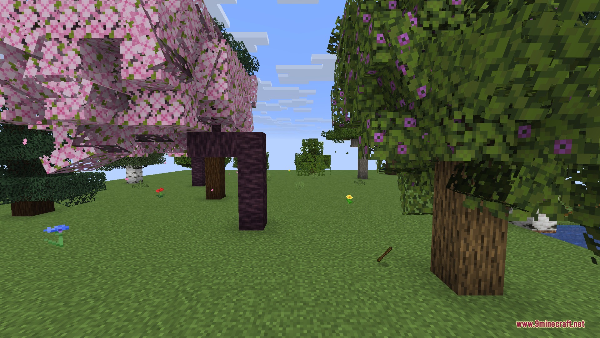Bushy cherry blossom and azalea trees standing in a grassy Minecraft field