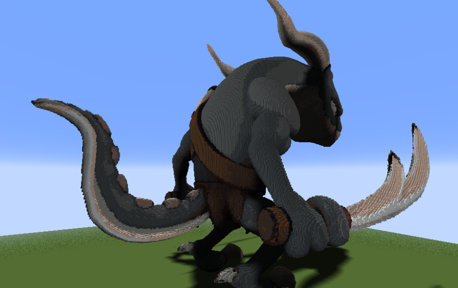 Rear view of the giant monster sculpture showing its long thick tail