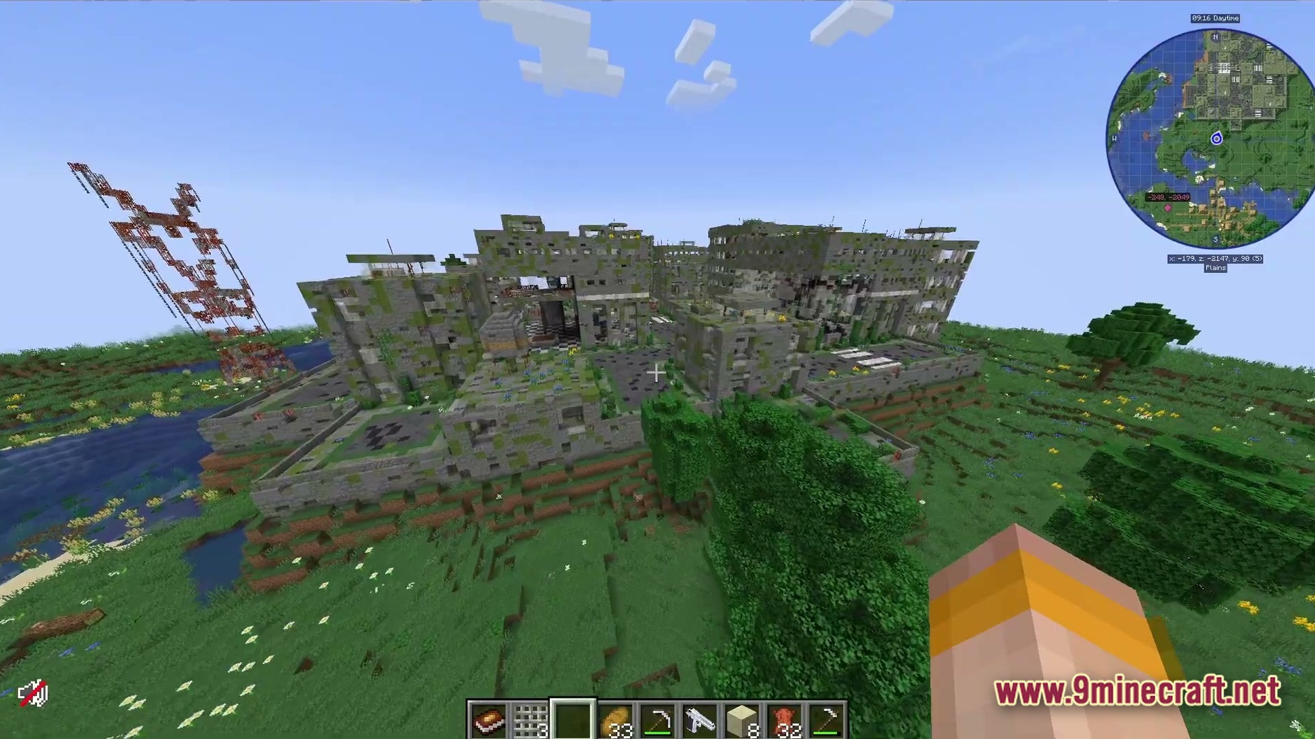 Deadbolt Tactical Survival Modpack Screenshot 2 An abandoned, overgrown concrete building complex situated within a grassy plains biome